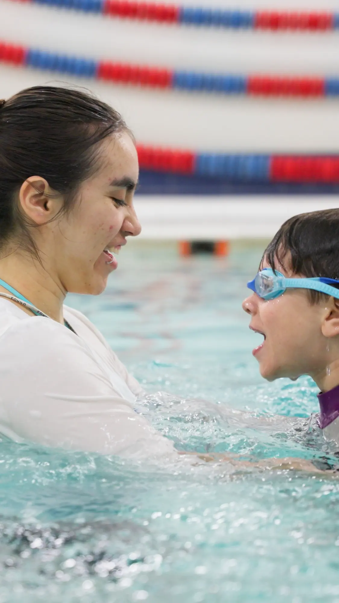 A child and Seal Swimming swim teacher share a joyful moment during a lesson.